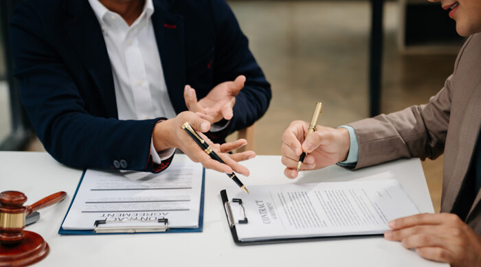 Two male attorneys discuss how to file a defamation lawsuit.