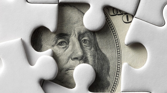 Close up view of Benjamin Franklin’s face on green monetary bills.